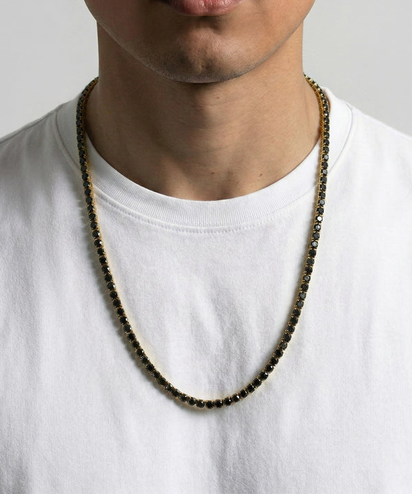Person wearing a beaded necklace on a plain background