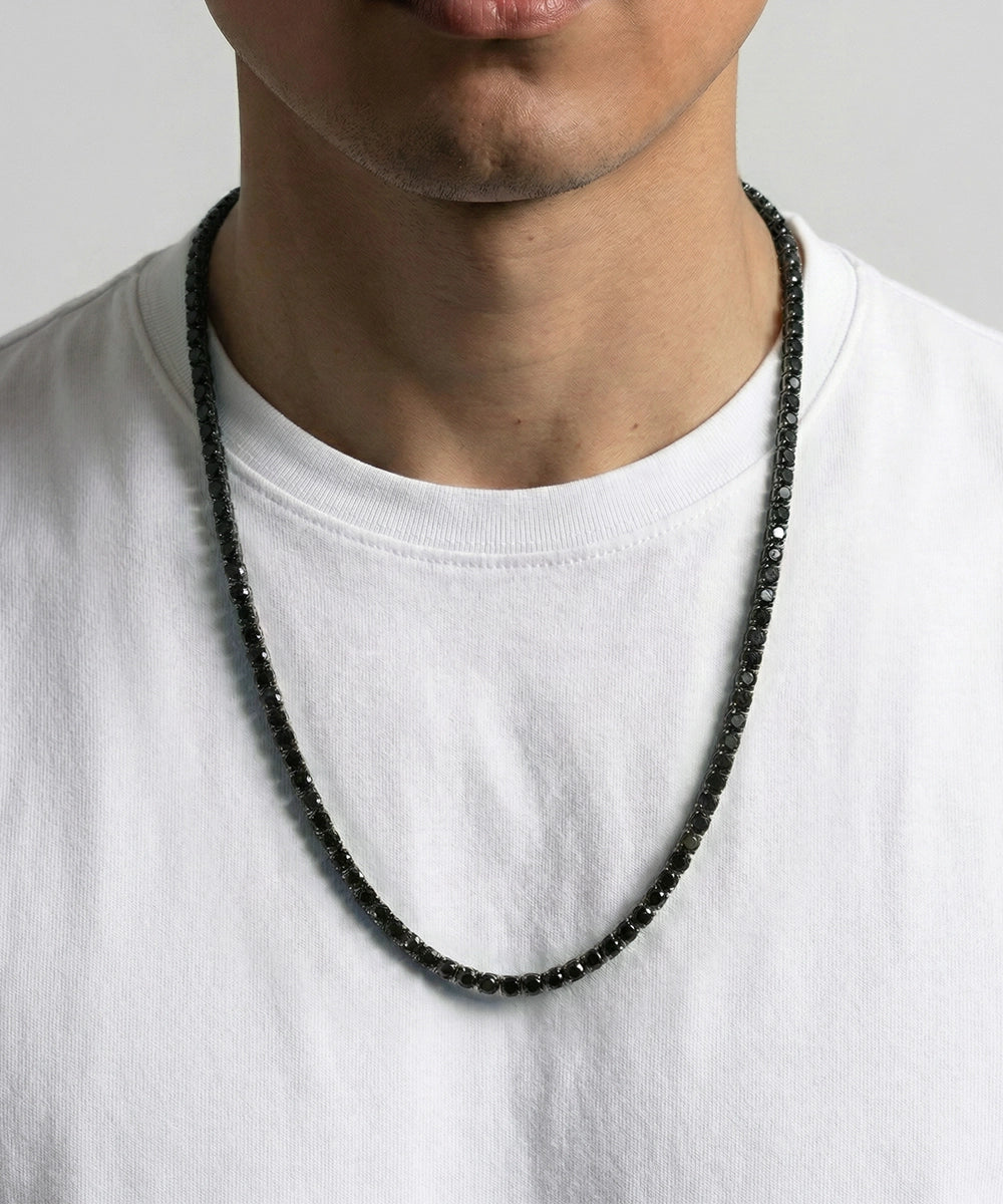 Person wearing a beaded necklace on a plain background