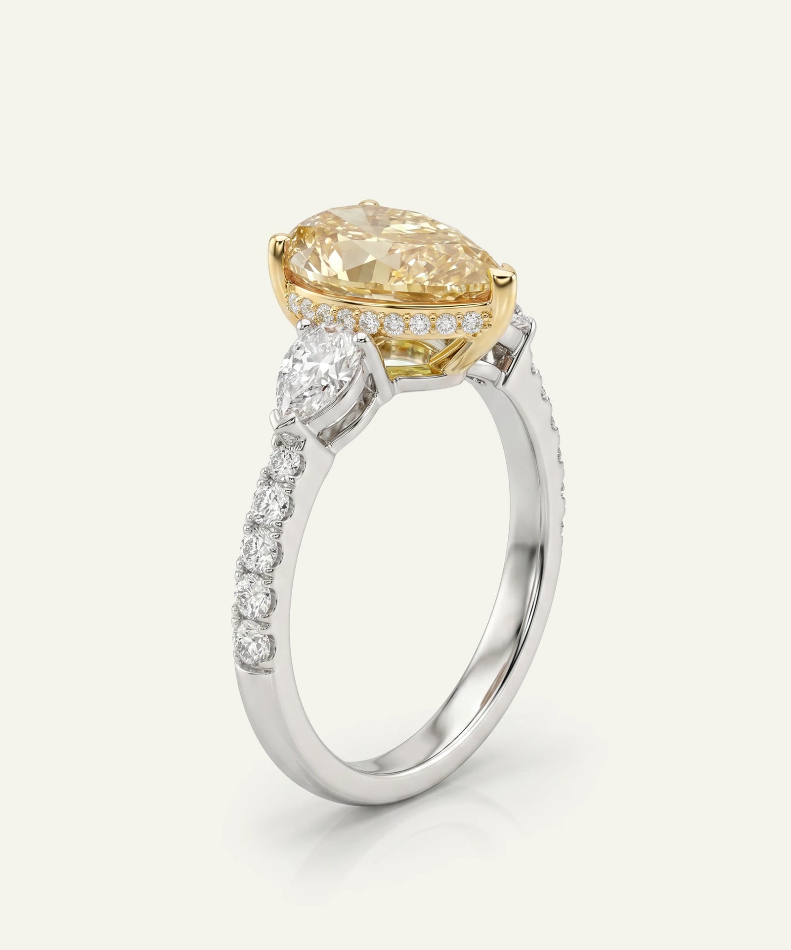 Gold and silver ring with a large yellow gemstone on a white background