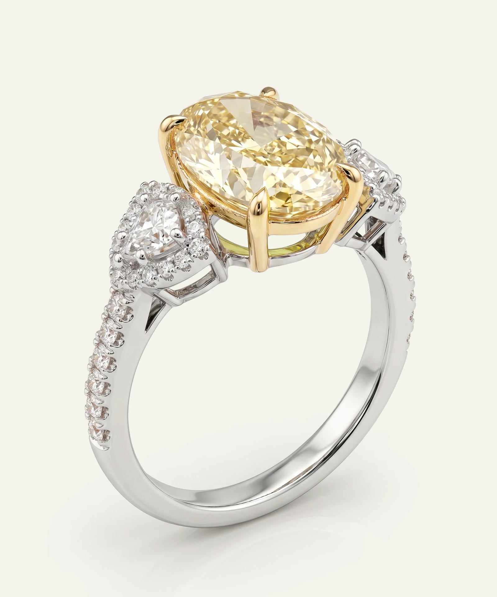 Gold and silver ring with a large yellow diamond and smaller diamonds on a white background