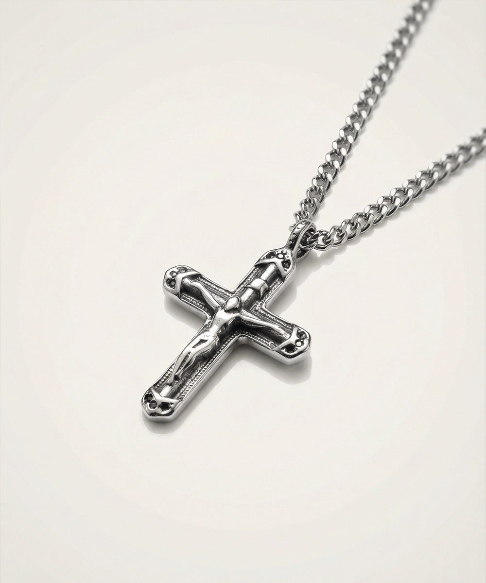 Silver cross necklace on a white background