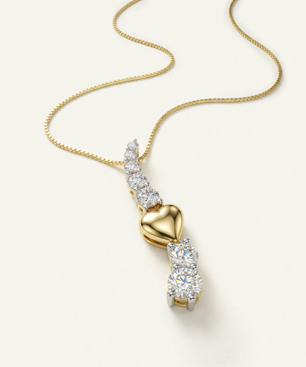 Gold necklace with a heart-shaped pendant on a white background