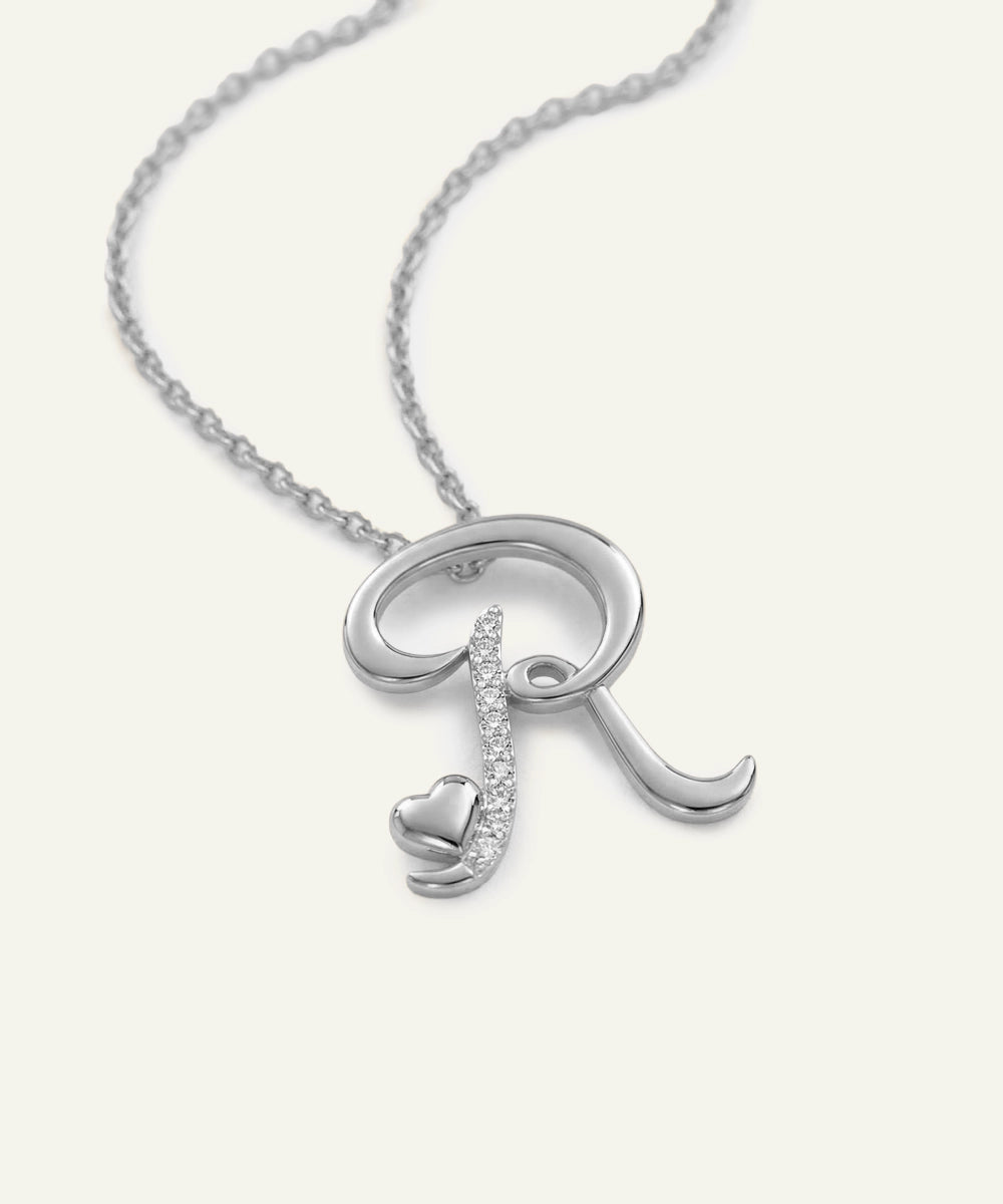 Silver necklace with a letter 'R' pendant on a white background