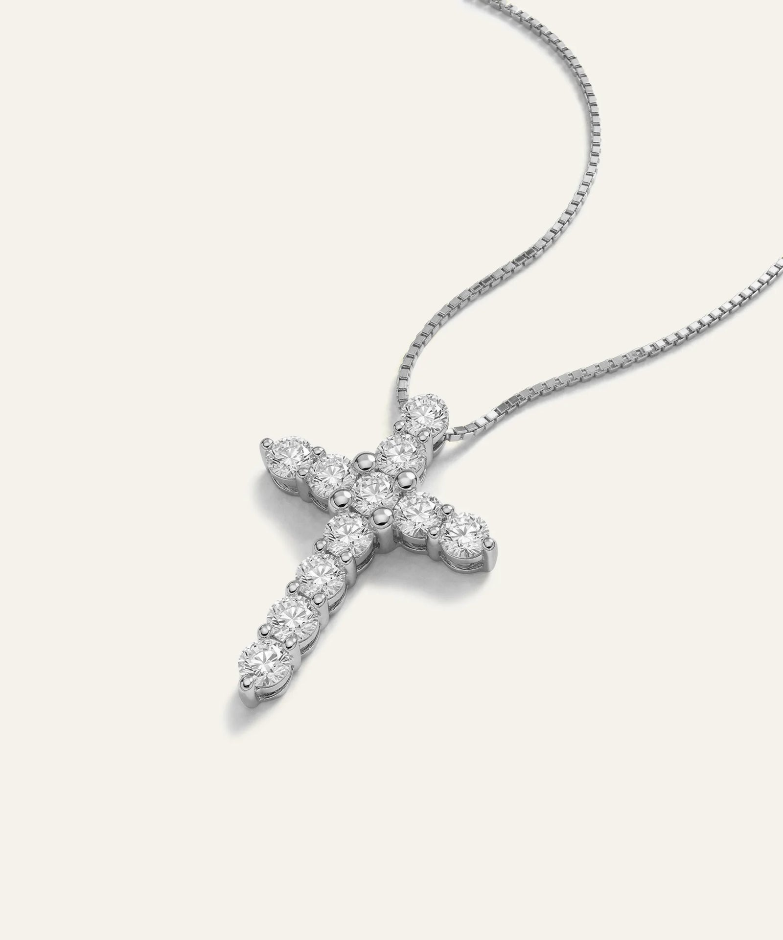 Silver cross pendant necklace on a white background