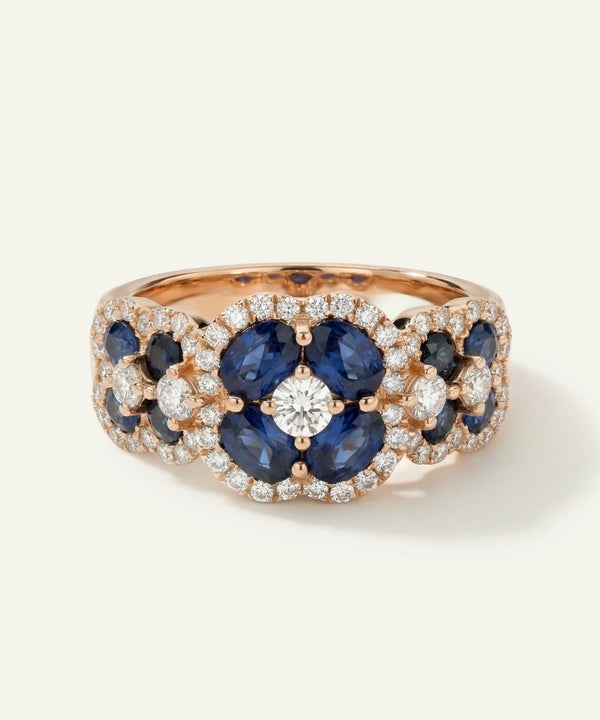 Rose gold ring with blue gemstones and diamonds on a white background