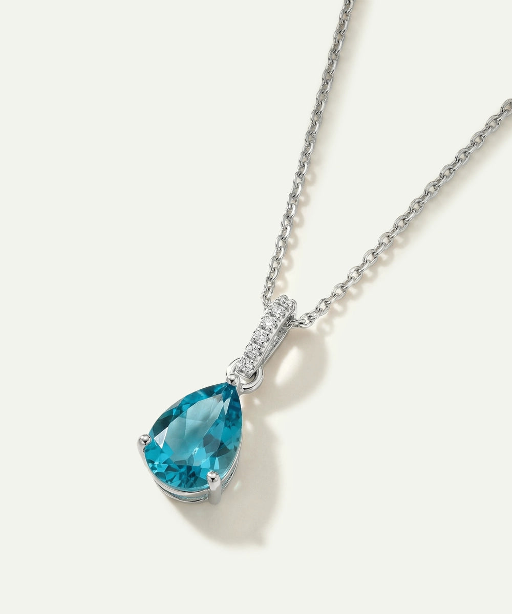Teardrop-shaped blue gemstone necklace on a white background