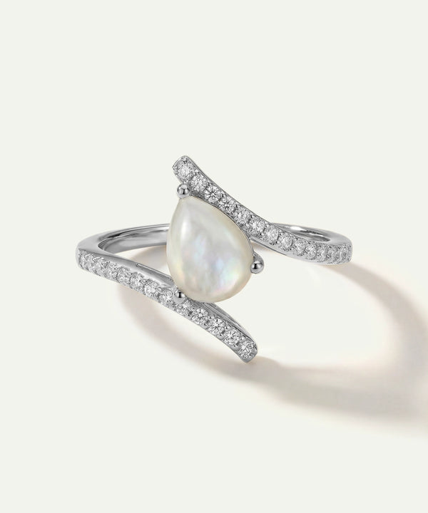 Silver ring with a pearl and small diamonds on a white background