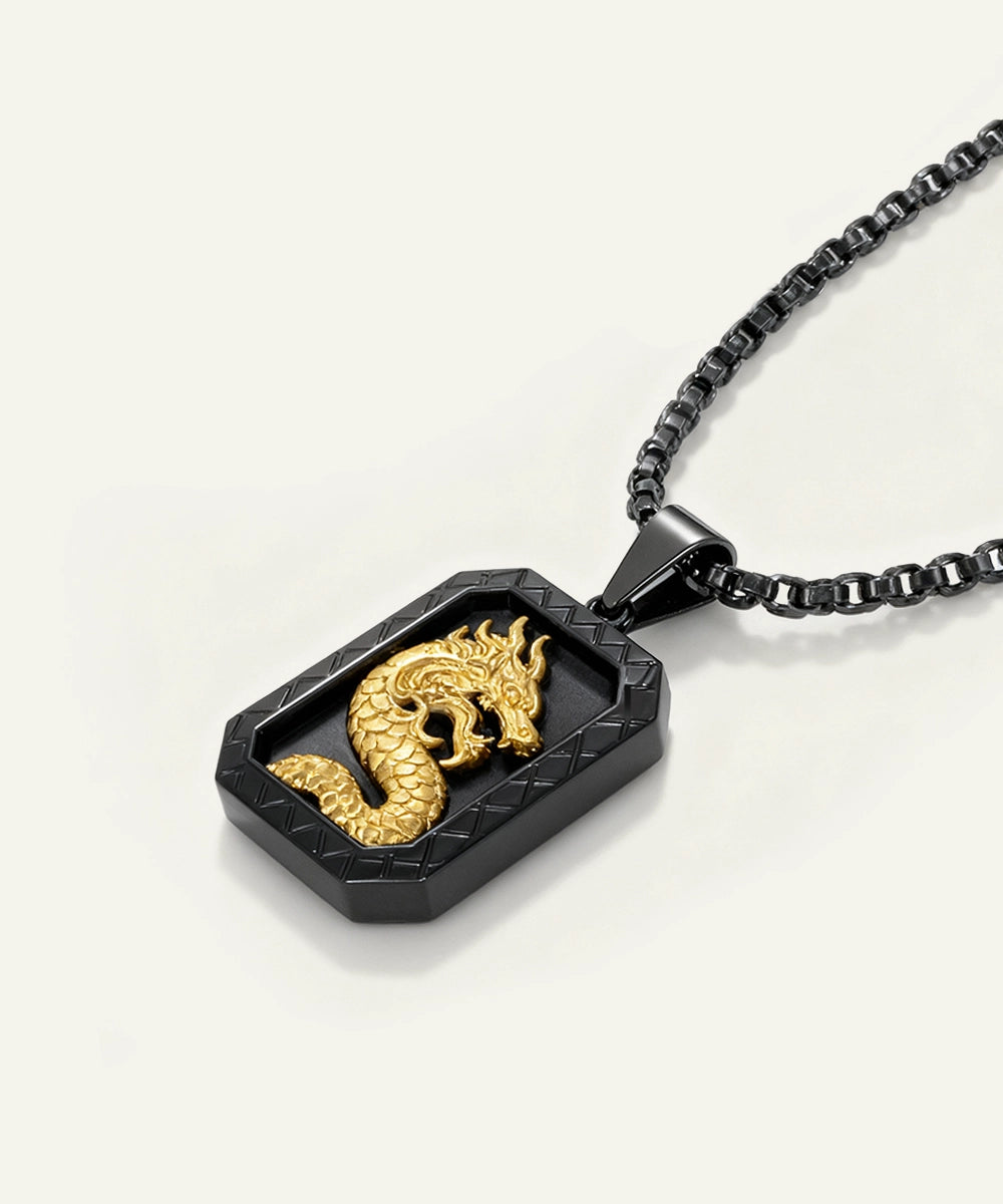 Gold dragon pendant on a black chain against a white background