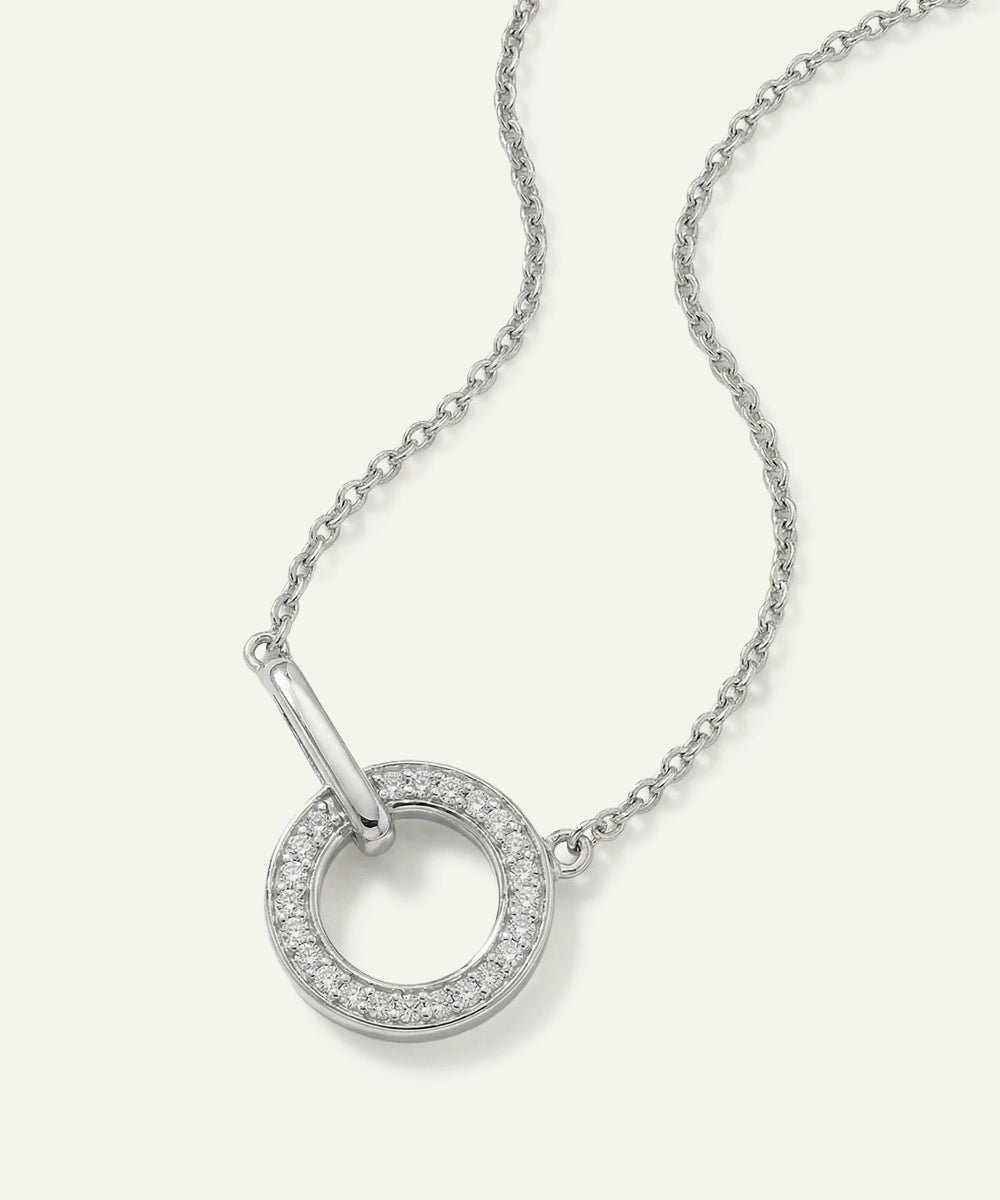 Silver necklace with a circular pendant on a white background