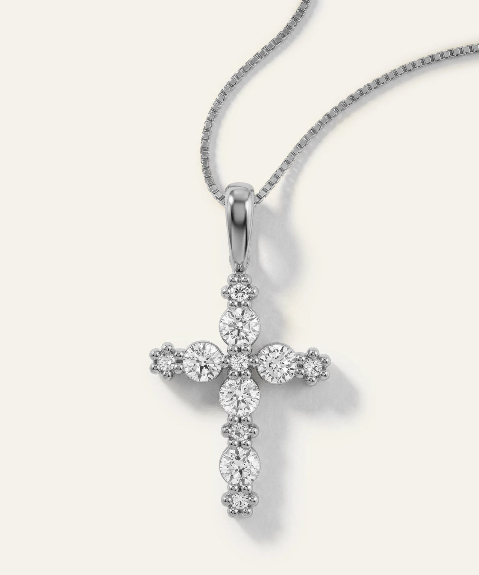Silver cross pendant necklace on a white background