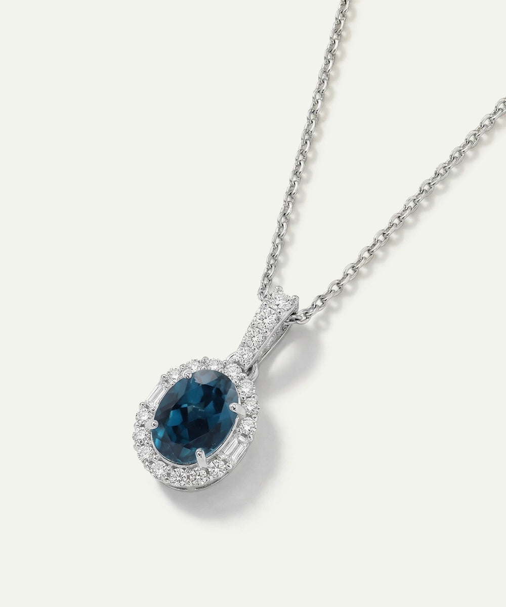 Silver necklace with a blue gemstone pendant on a white background