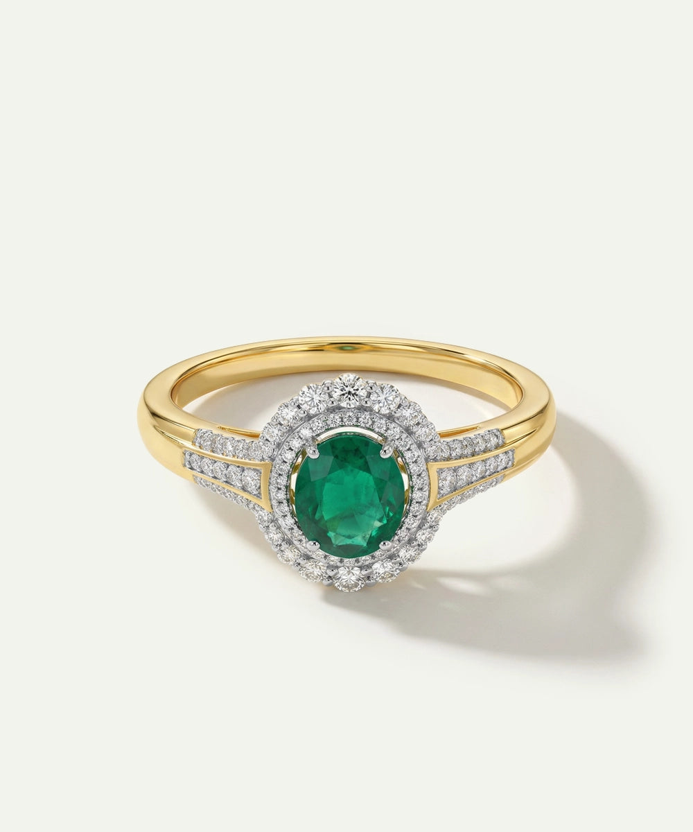 Gold ring with a green gemstone and diamond accents on a white background