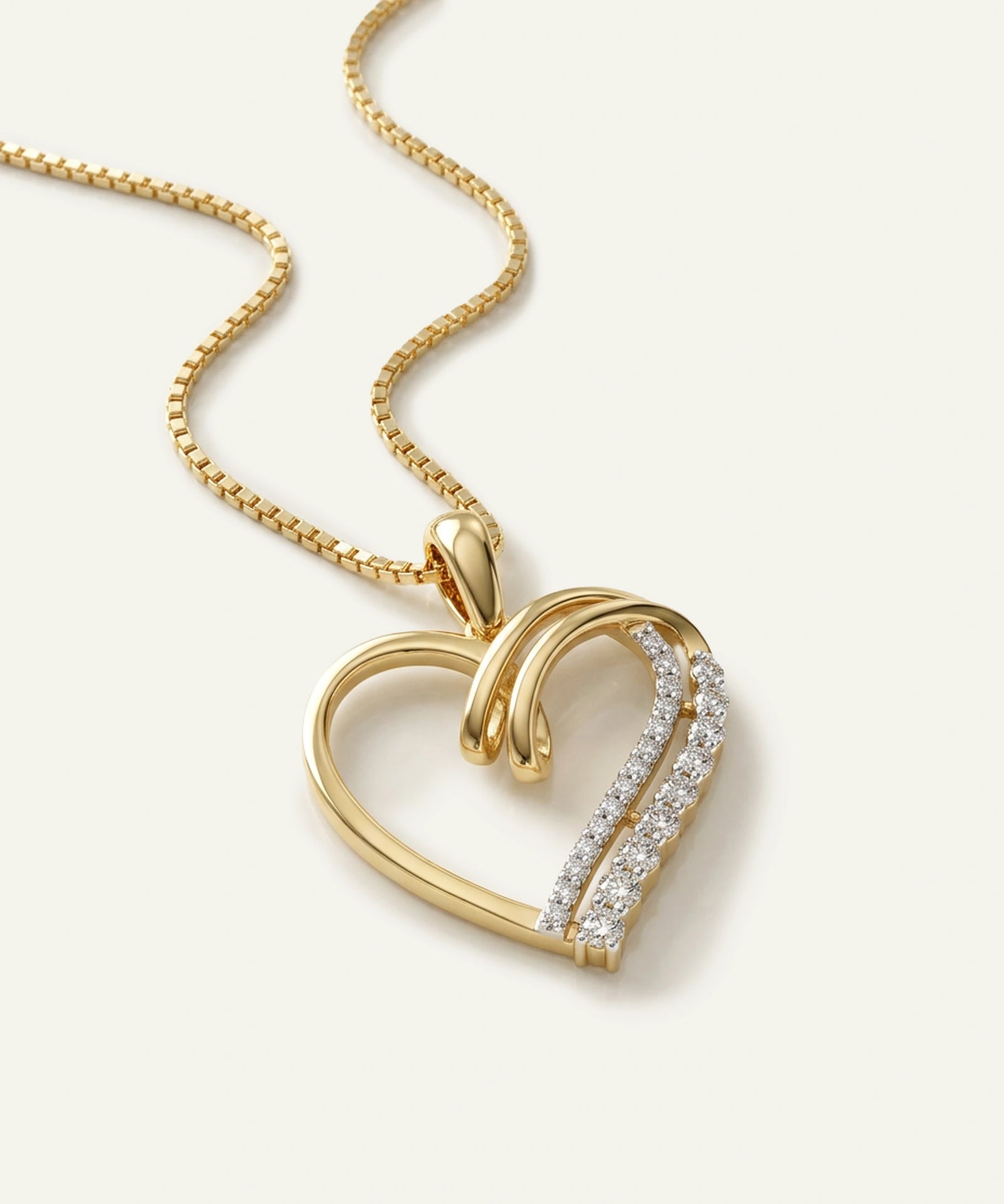Gold heart-shaped necklace with diamond accents on a light background