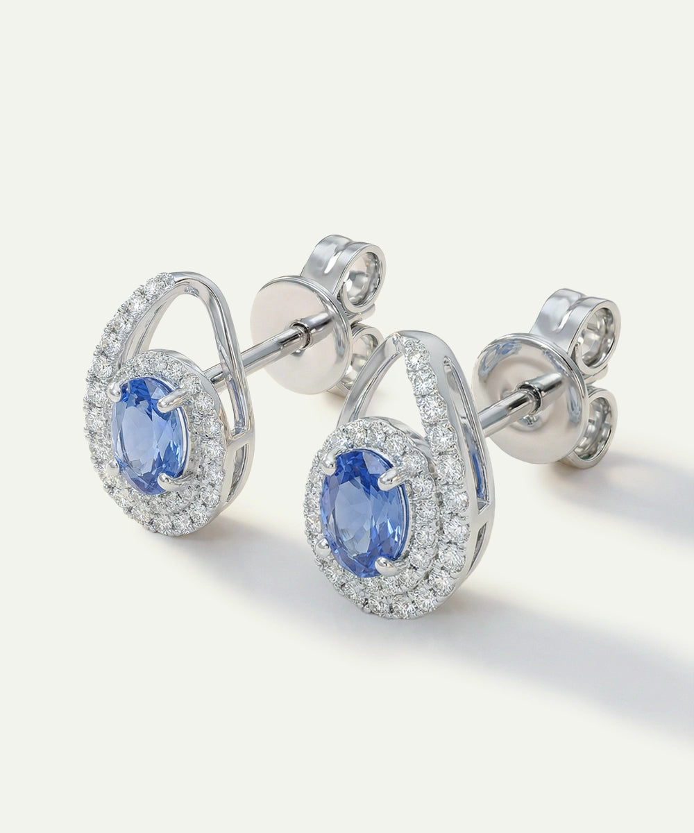 Pair of silver earrings with blue gemstones on a white background