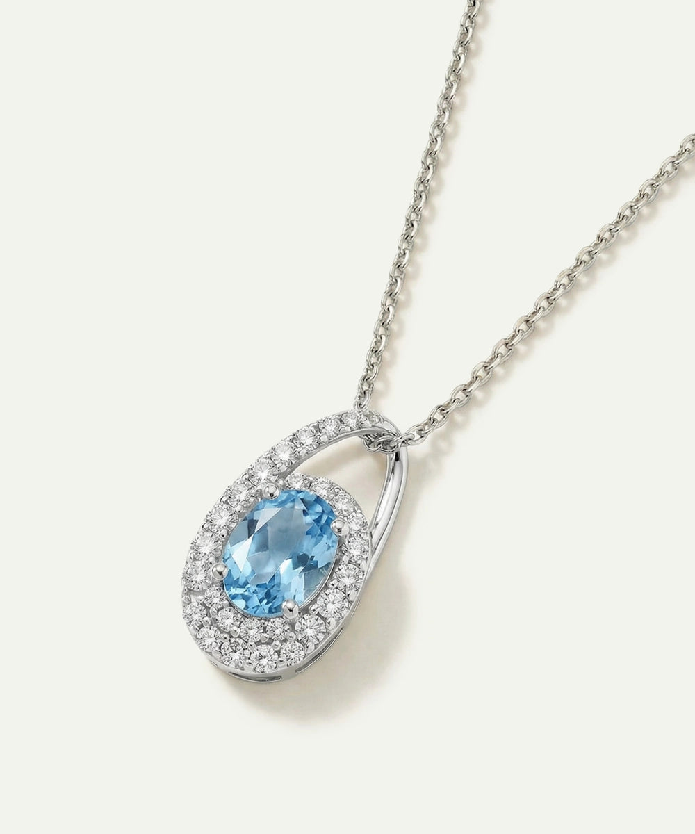 Silver pendant with a blue gemstone on a white background