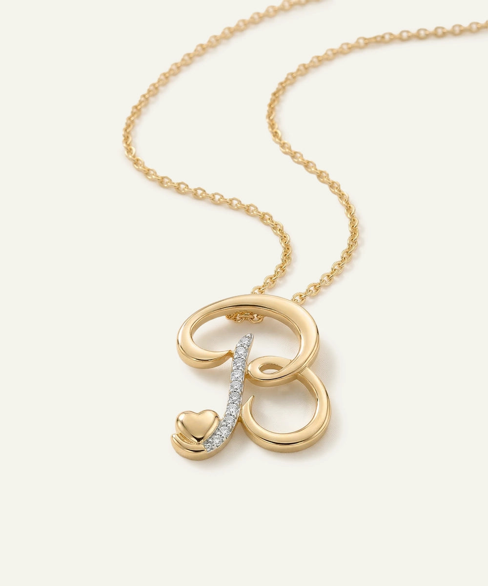 Gold necklace with a heart-shaped pendant and diamond accents on a white background