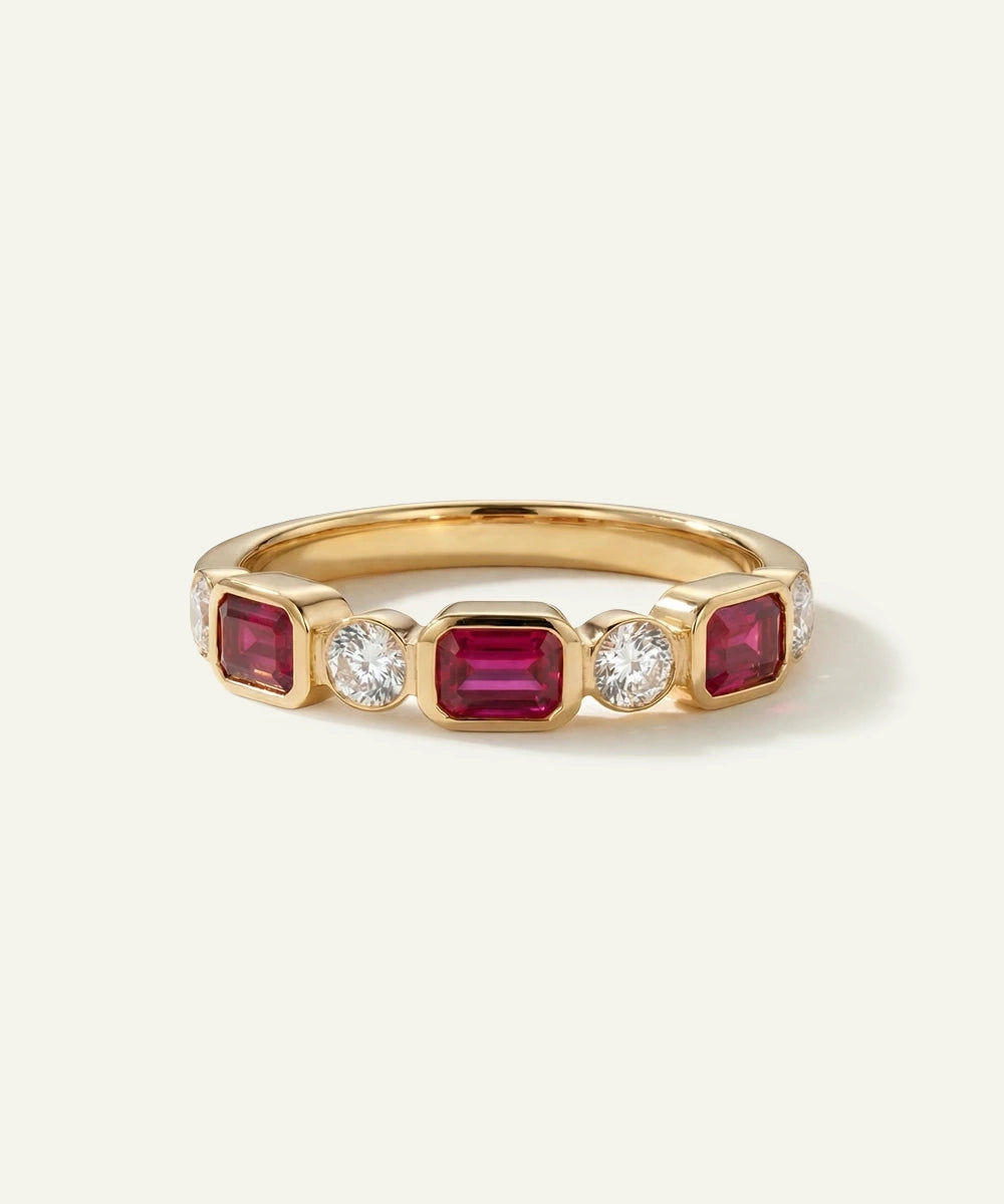 Gold ring with red gemstones and clear stones on a white background
