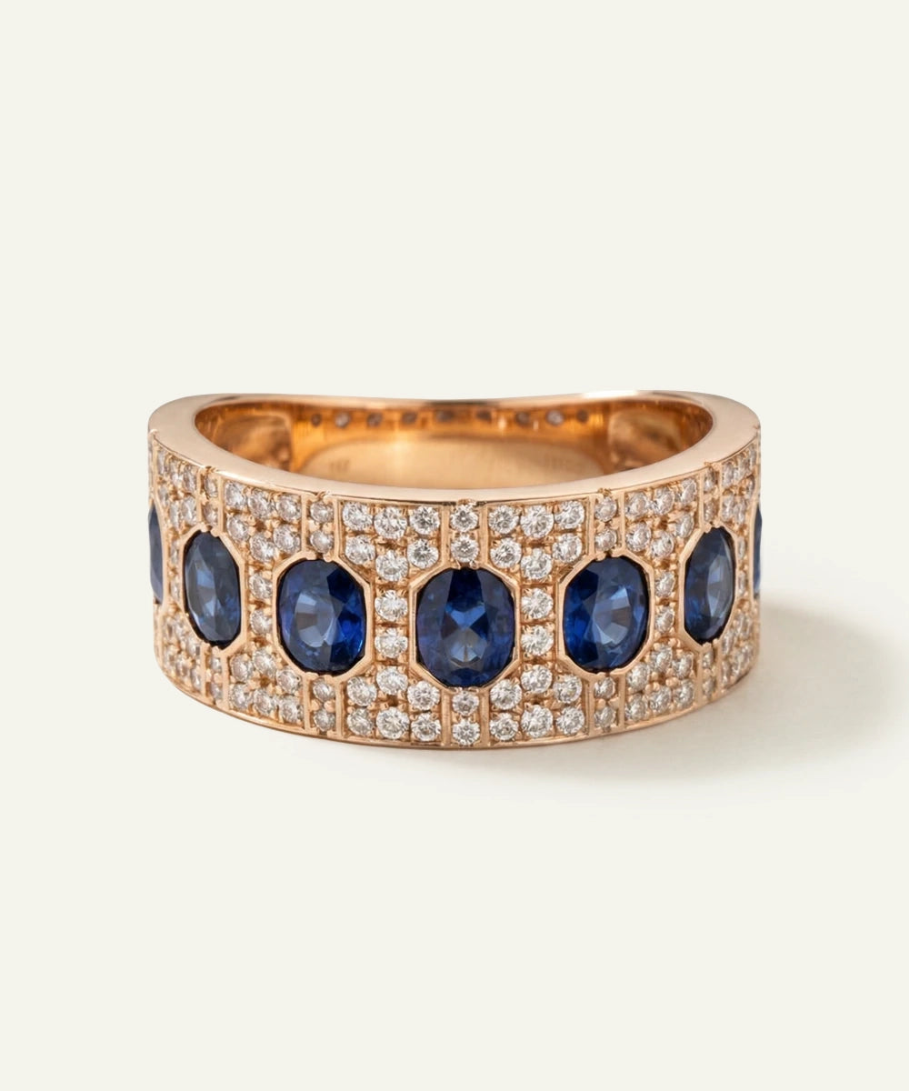 Rose gold ring with blue gemstones and diamonds on a white background