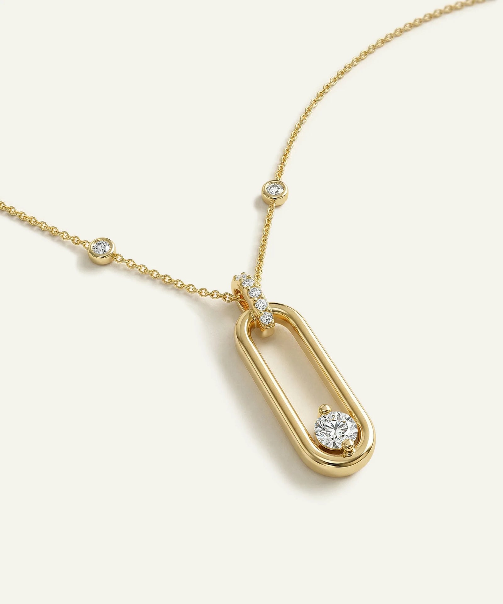Gold necklace with a pendant on a light beige background