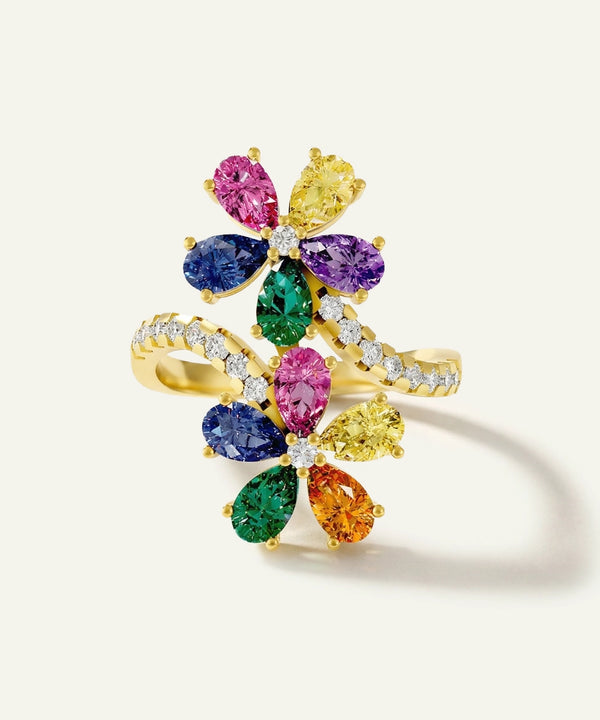 Multicolored gemstone ring with gold band on a light background