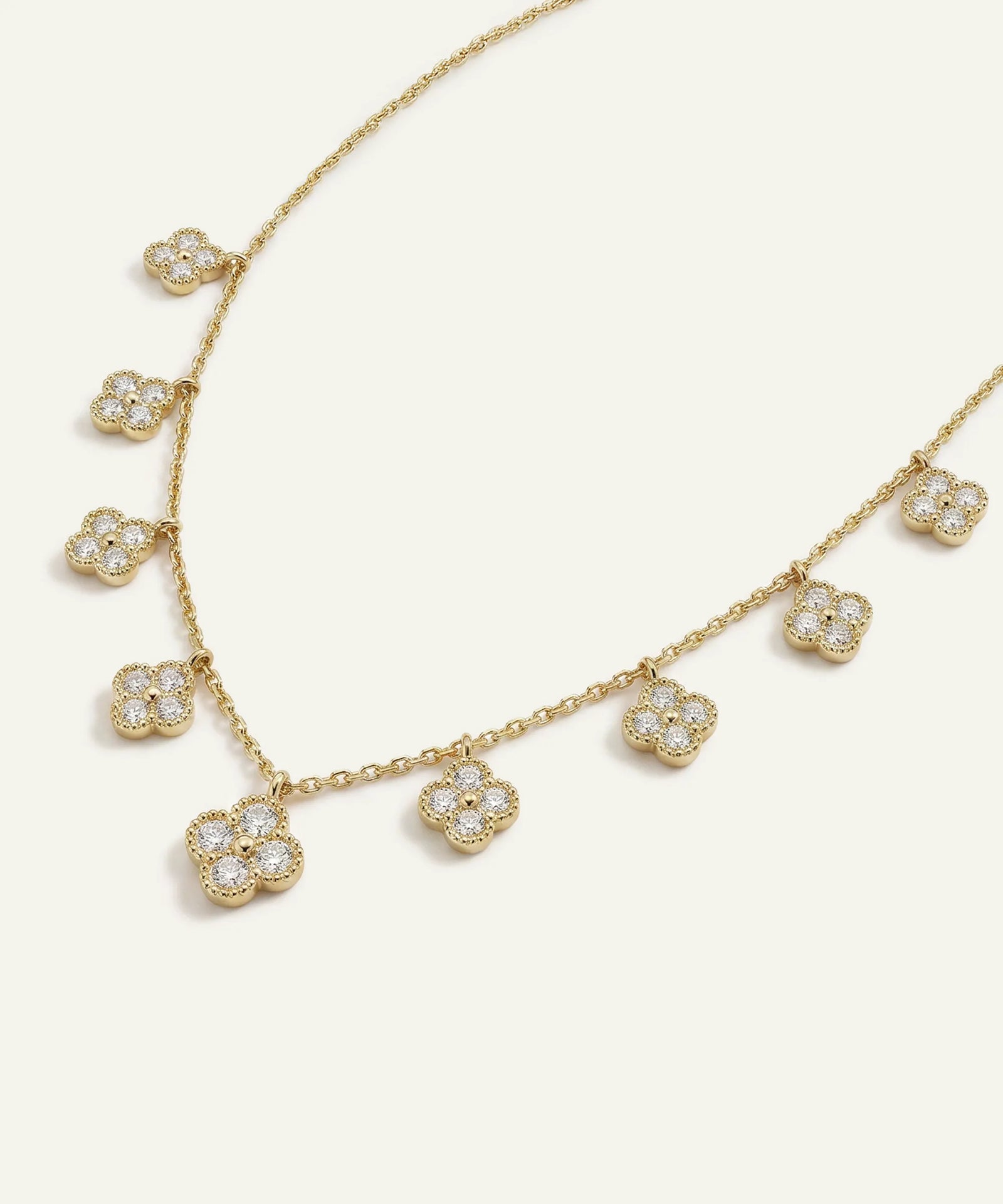 Gold necklace with floral pendant on a white background