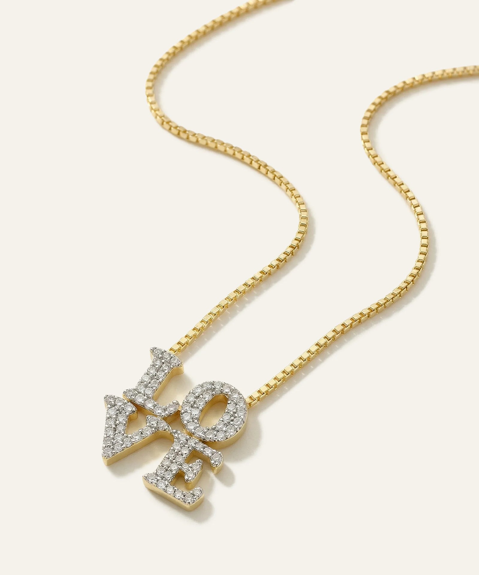 Gold necklace with 'LOVE' pendant on a white background