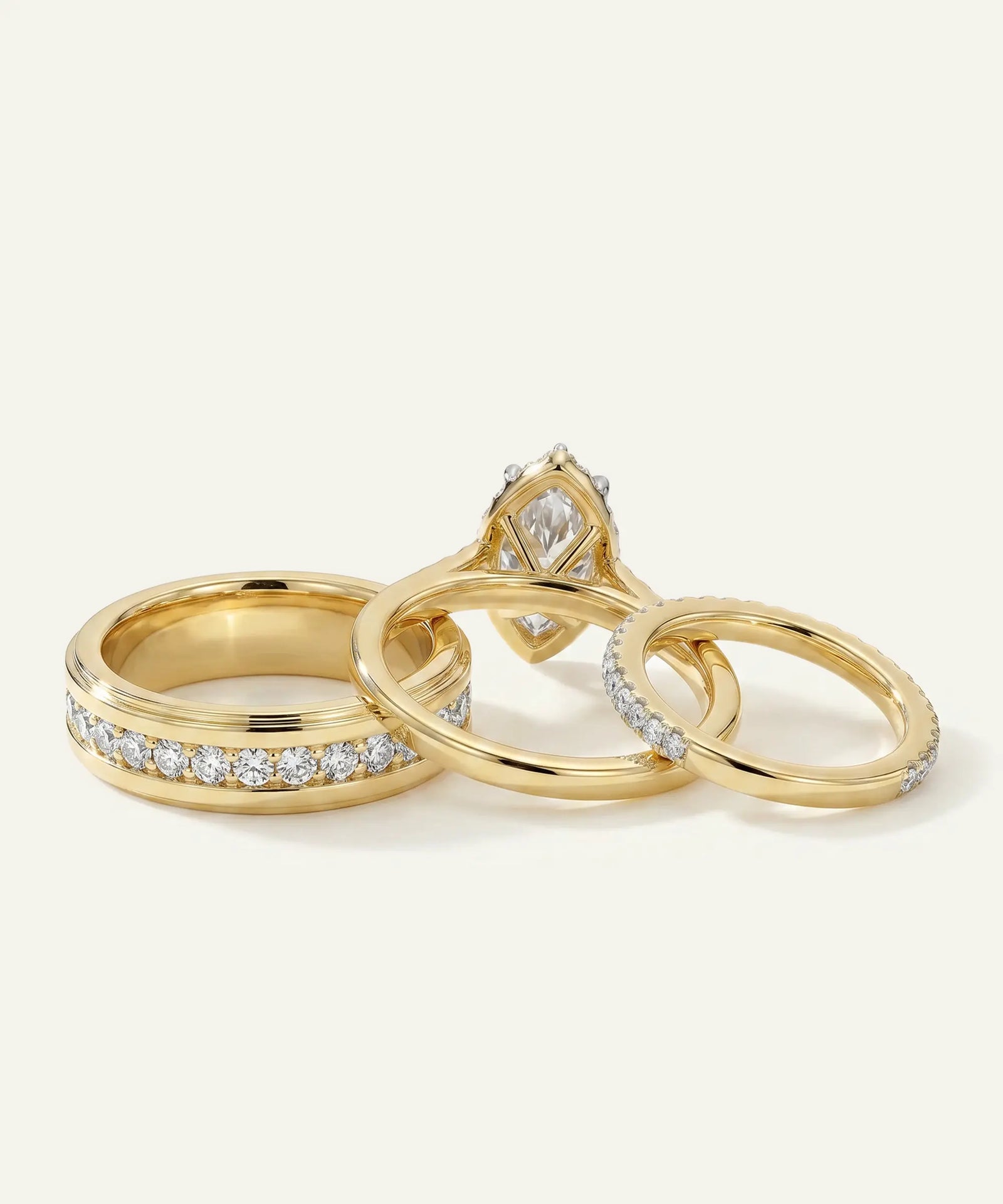 Three gold rings with diamond accents on a light background