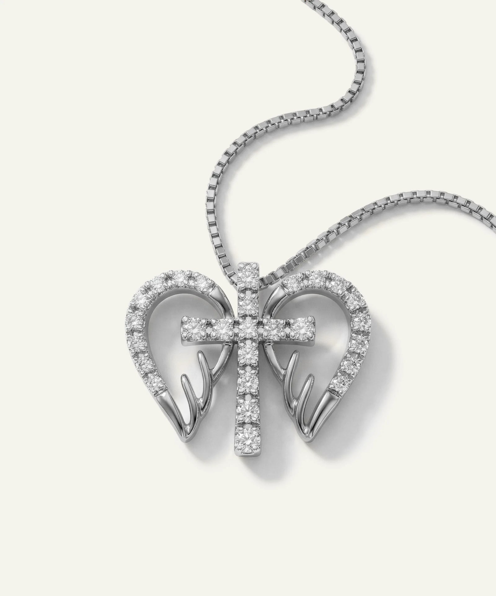 Silver heart-shaped pendant with a bow design on a white background