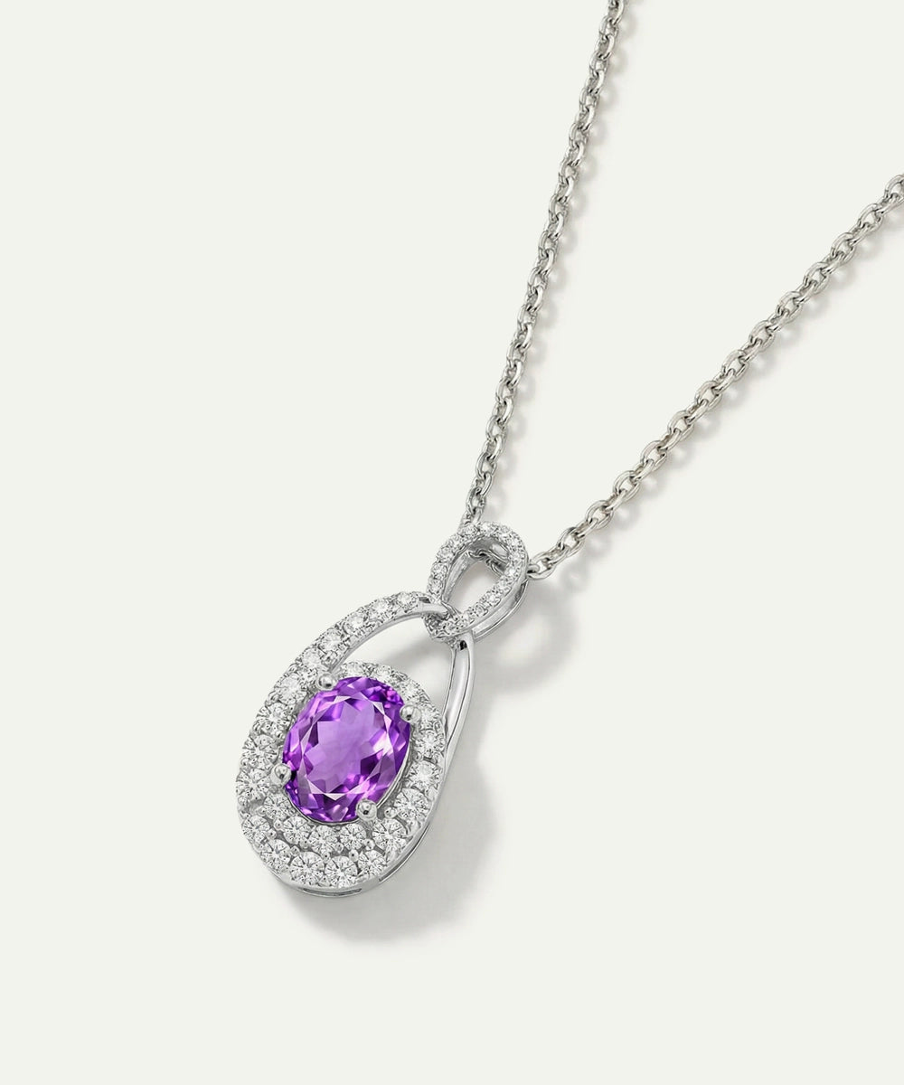Silver necklace with a purple gemstone pendant on a white background