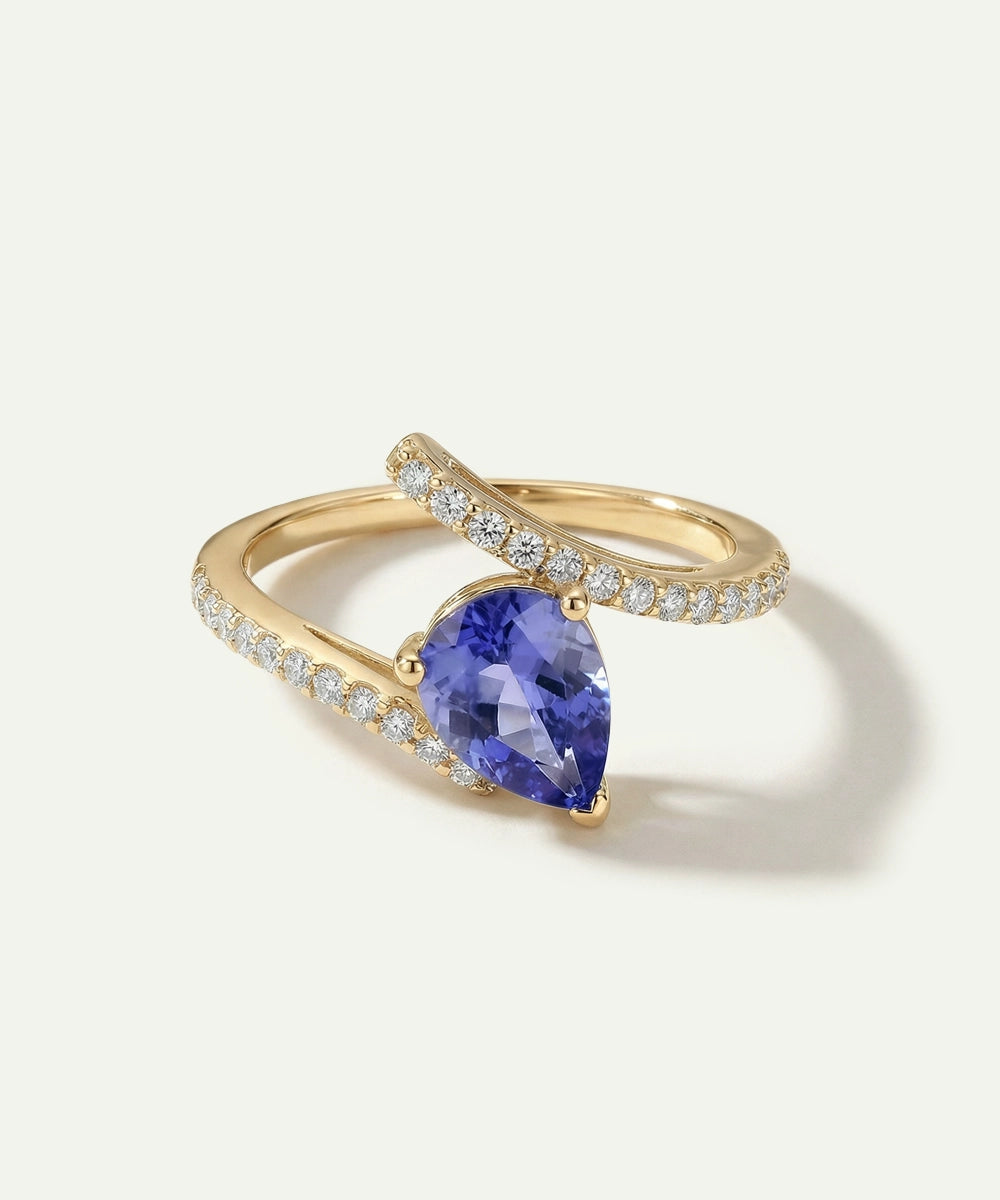 Gold ring with a blue gemstone on a white background