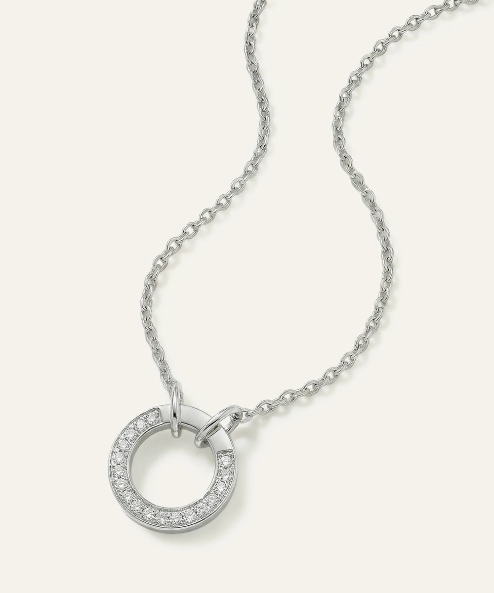 Silver necklace with a circular pendant on a white background