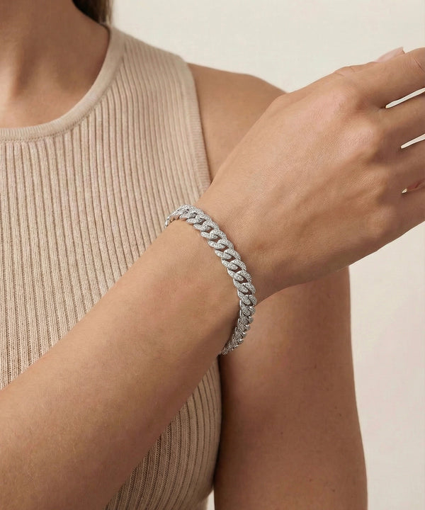 Silver bracelet on a person's wrist with a neutral background