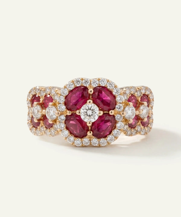 Elegant ring with red gemstones and diamonds on a white background