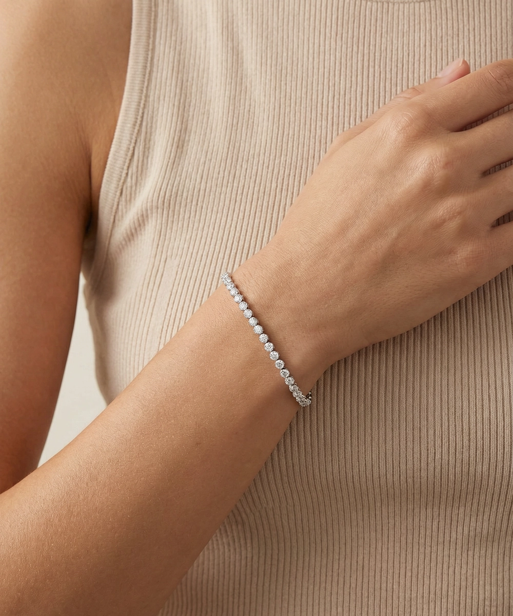 Silver bracelet on a wrist against a neutral background