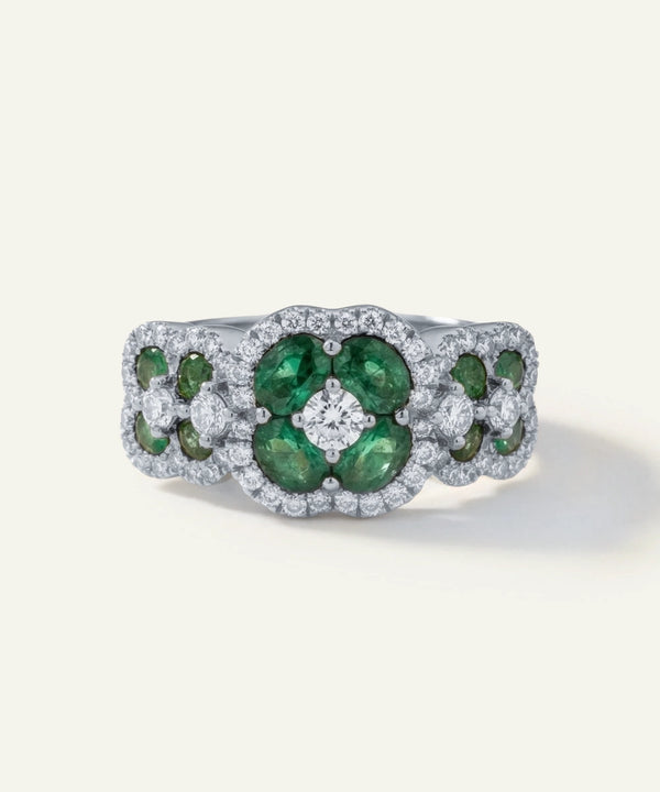 Ring with green gemstones and diamonds on a white background