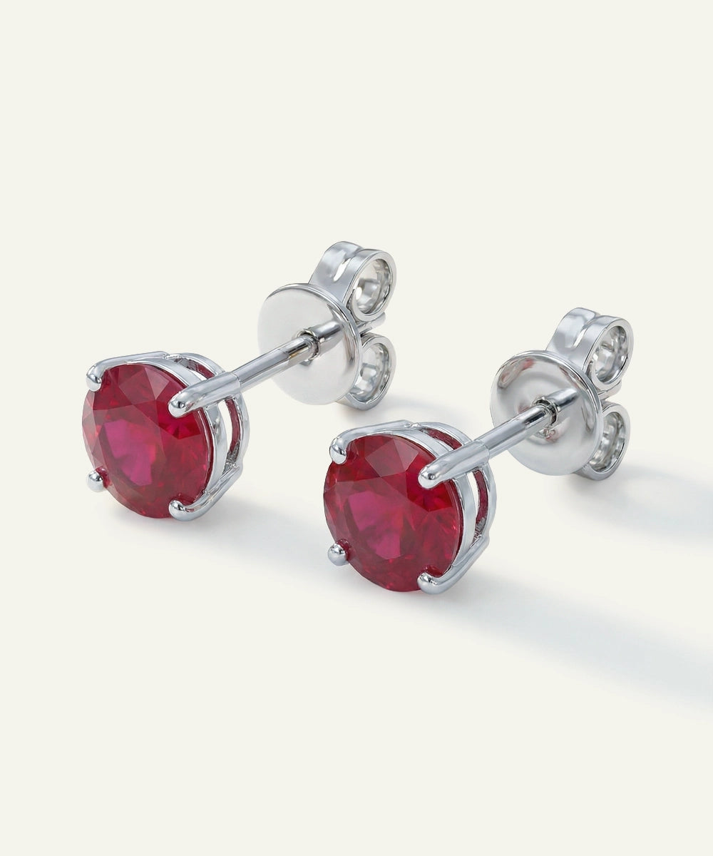 Silver earrings with red gemstones on a white background