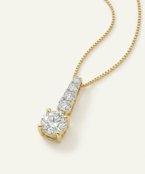 Gold necklace with a diamond pendant on a white background
