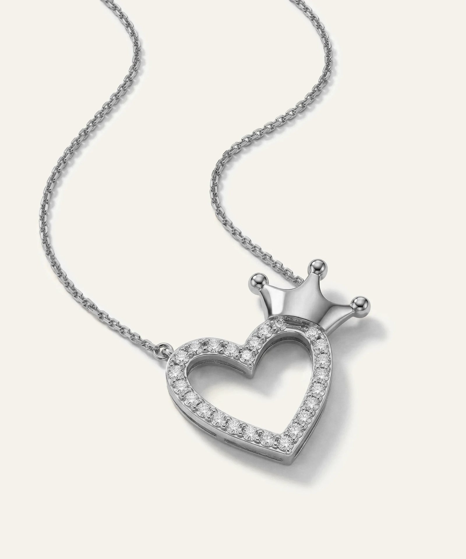 Silver heart-shaped necklace with a crown design on a white background
