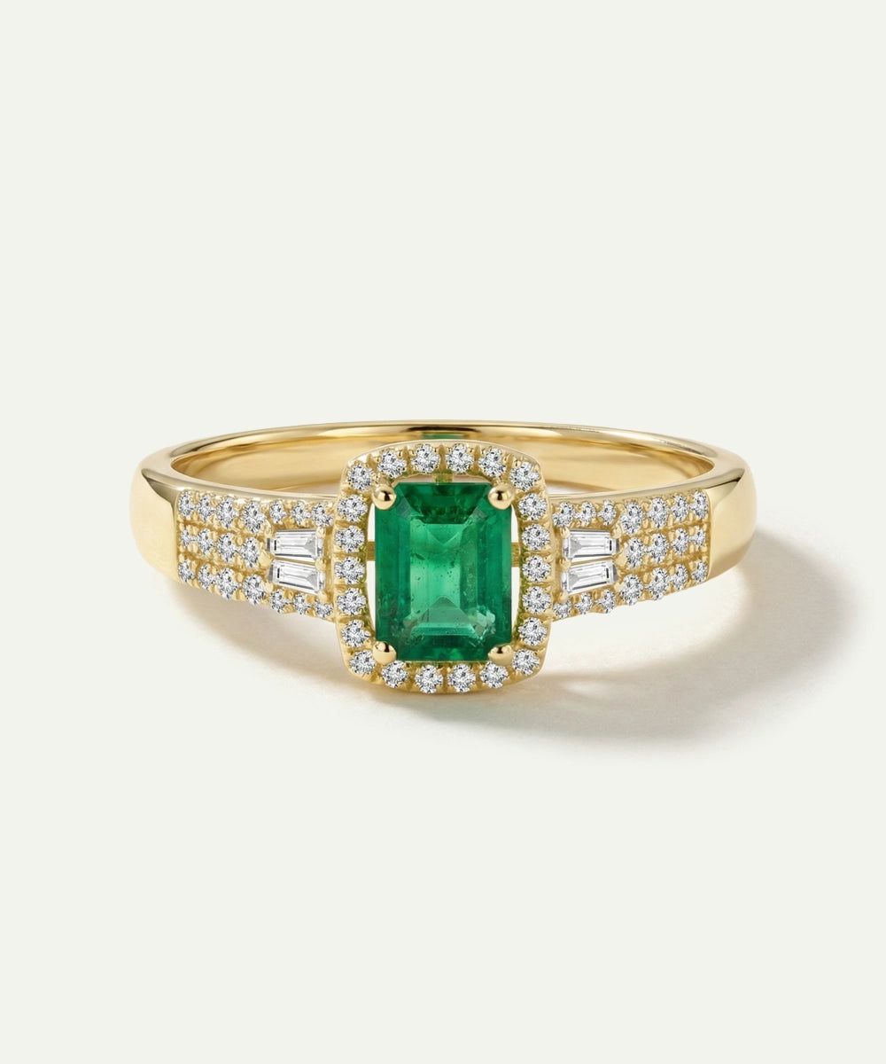 Gold ring with a green gemstone and diamond accents on a white background