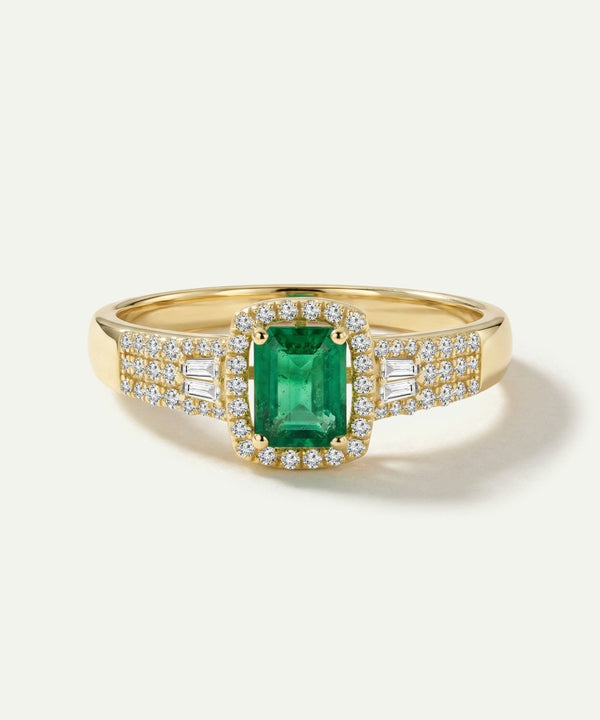 Gold ring with a green gemstone and diamond accents on a white background