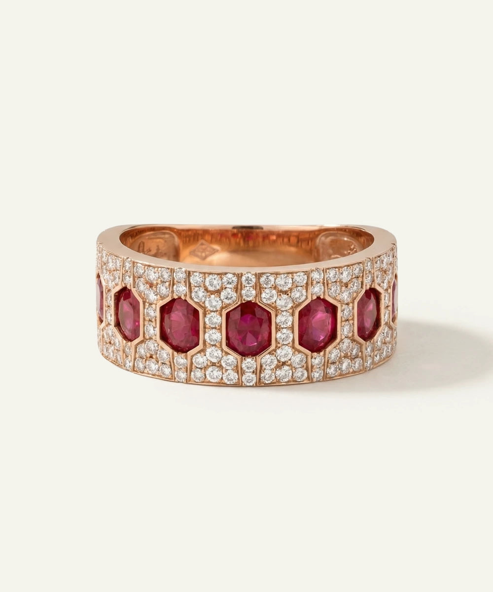 Rose gold ring with red gemstones and diamonds on a white background