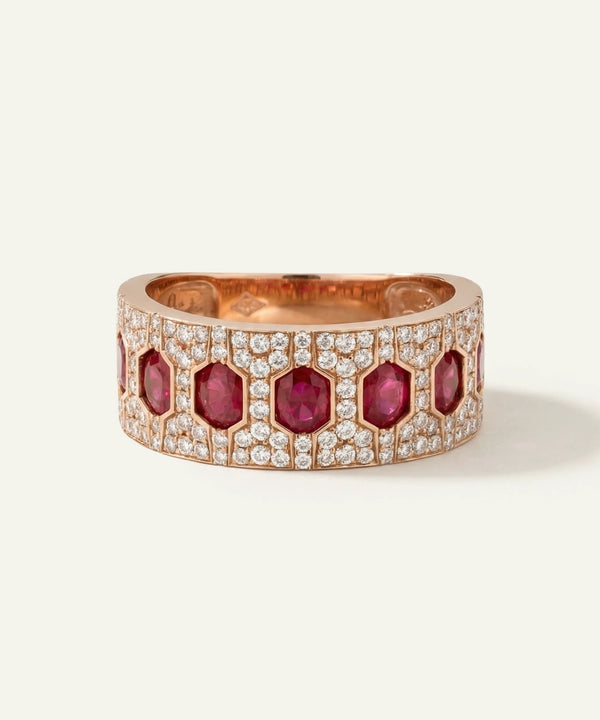 Rose gold ring with red gemstones and diamonds on a white background