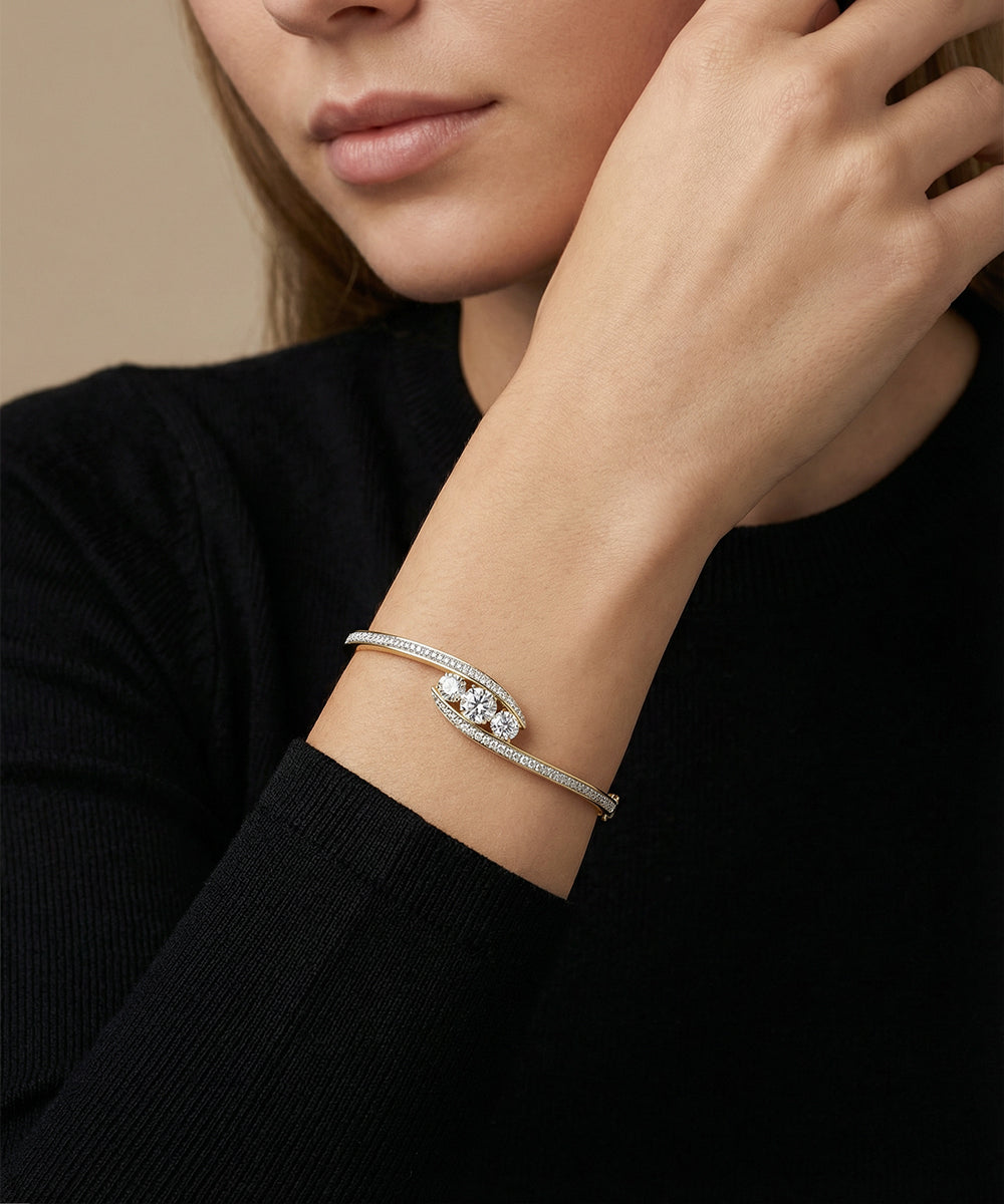 Woman wearing a silver bracelet with a clear gemstone on a beige background