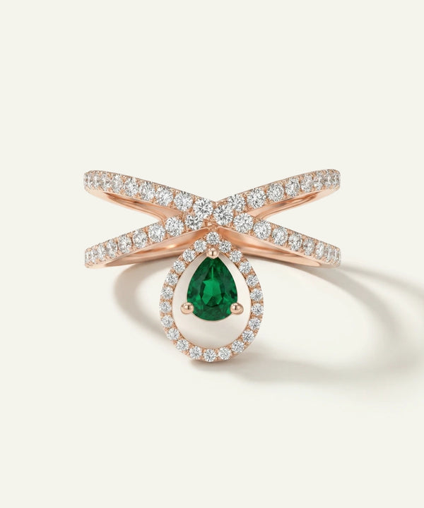 Rose gold ring with a green gemstone on a light beige background