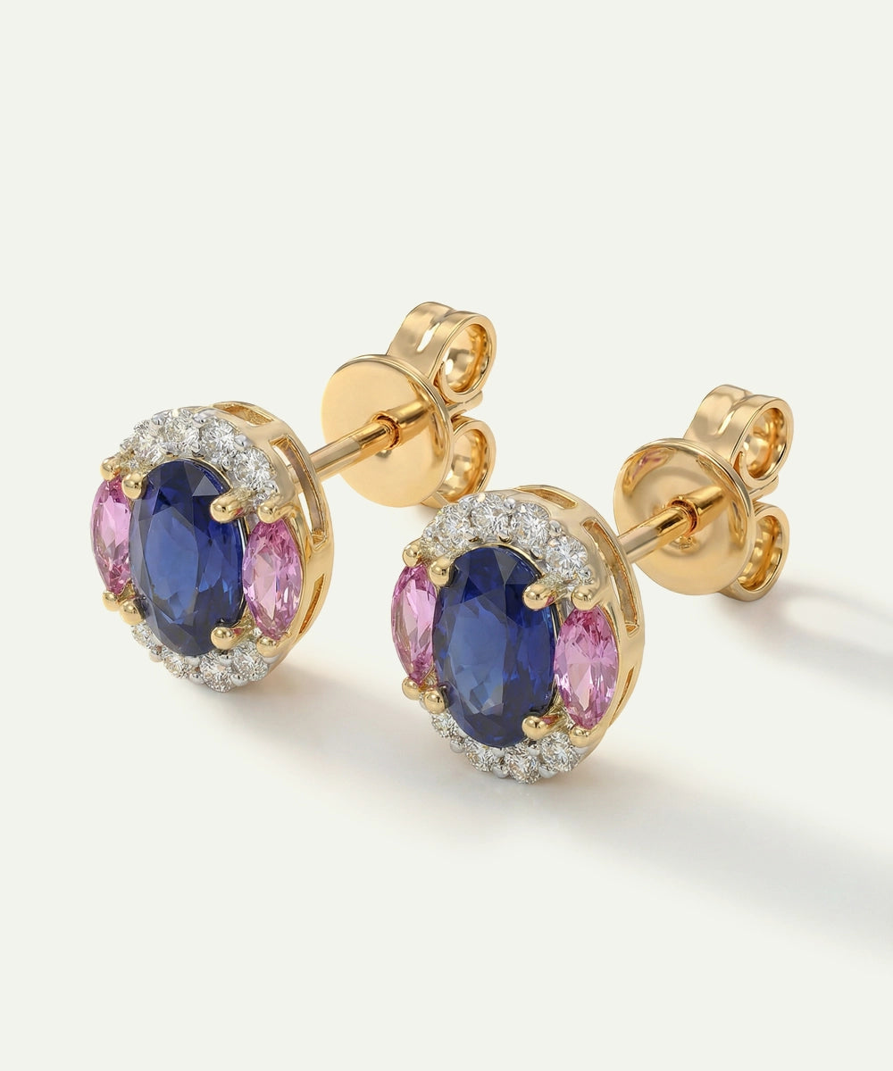 Gold earrings with blue and pink gemstones on a white background