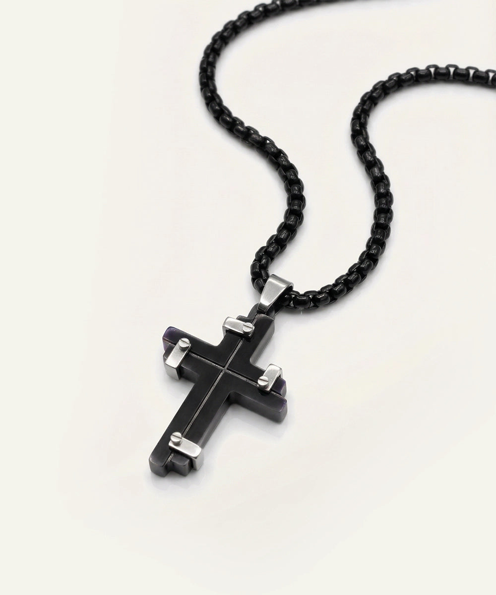 Black cross pendant necklace on a white background