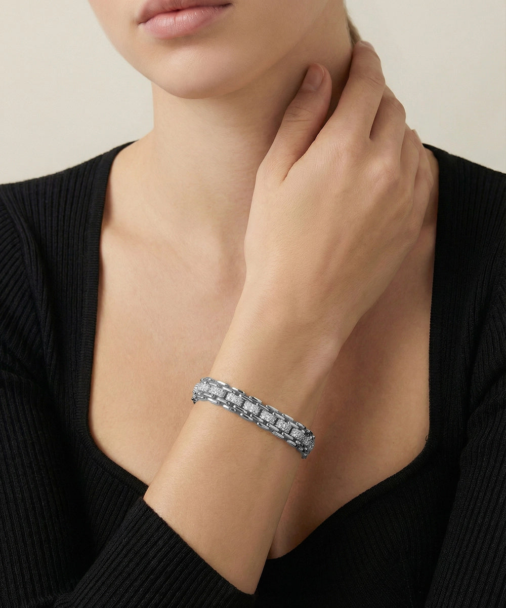 Person wearing a silver bracelet on a neutral background