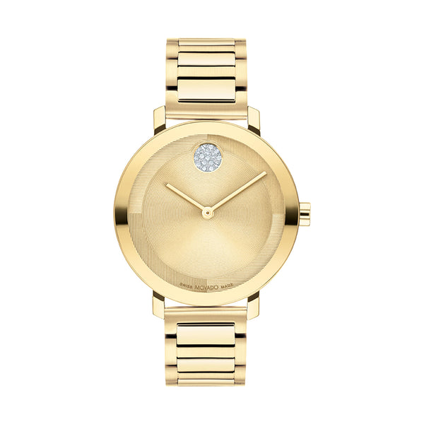 Gold watch with a diamond on the face against a white background