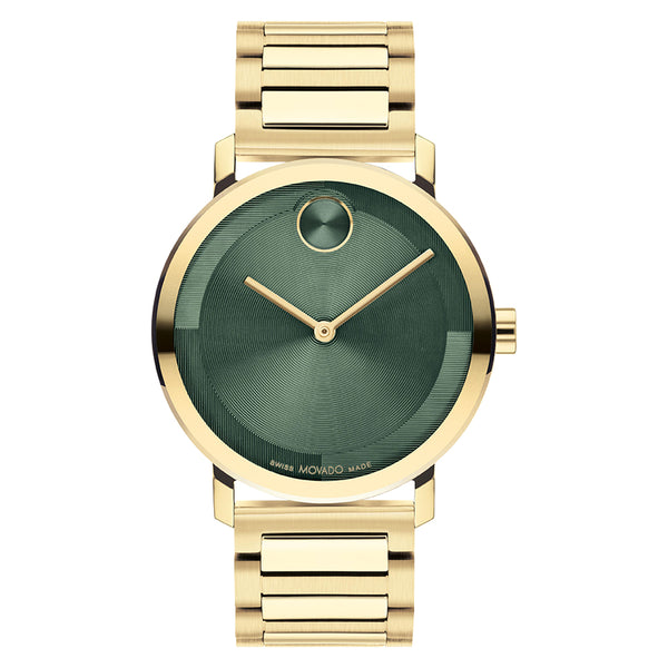 Gold watch with a green face on a white background