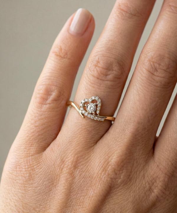 Rose gold ring with a diamond on a hand against a neutral background